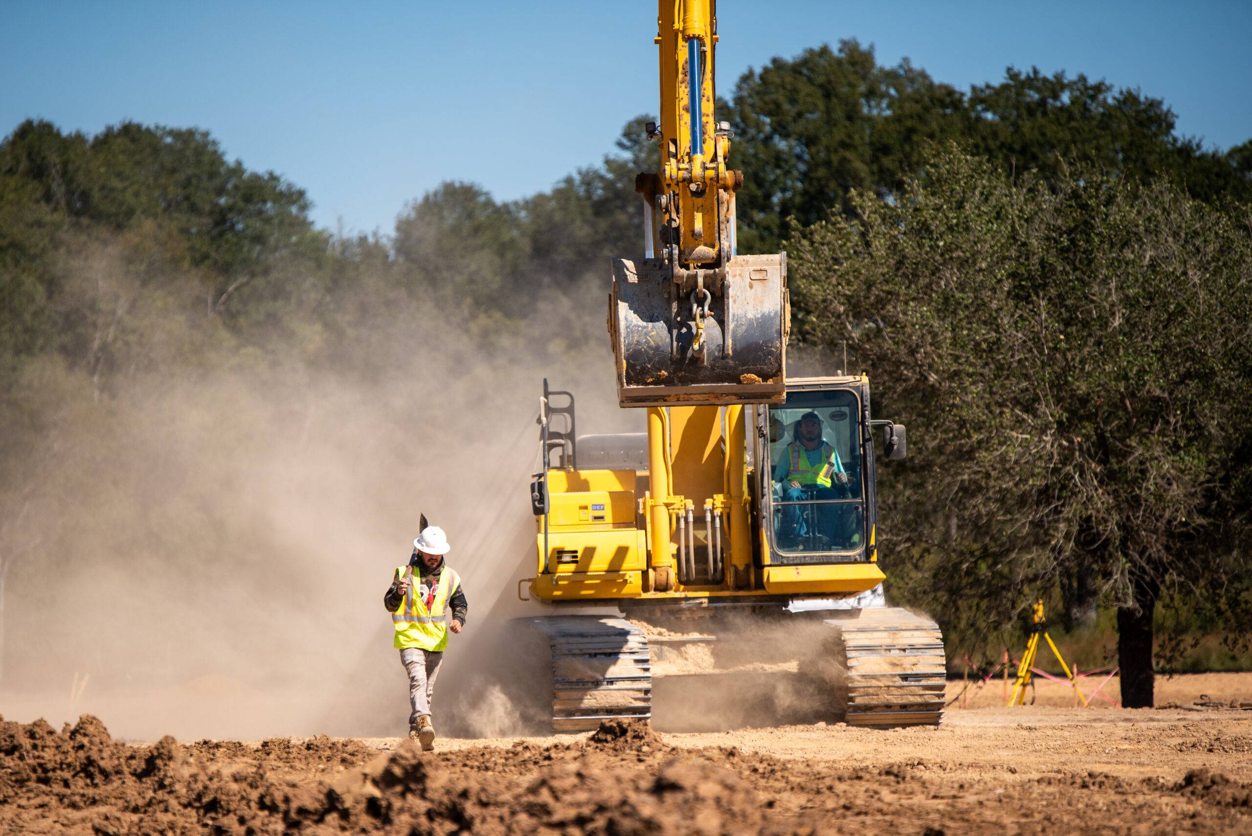 Excavator installing underground utility infrastructure for a commercial development in Texas
